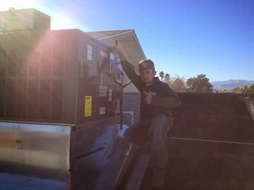 HVAC technician performing AC Tune-Up on a rooftop unit in Malvern